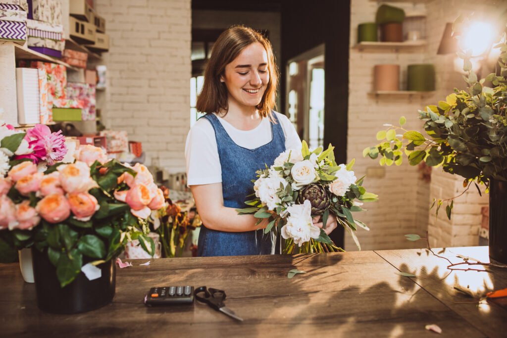 woman florist at her own floral shop taking care of flowers